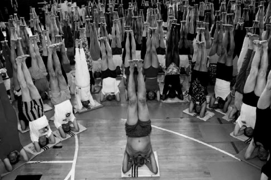 Iyengar practicing head balance (in 1993, at age 75) with students.
